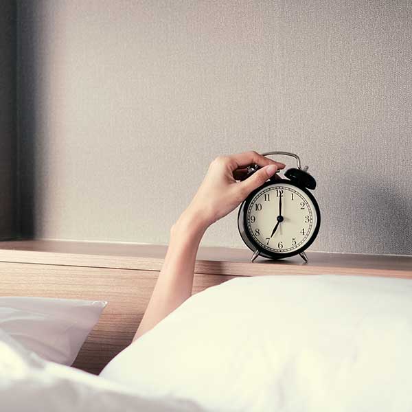 woman pushing an alarm clock